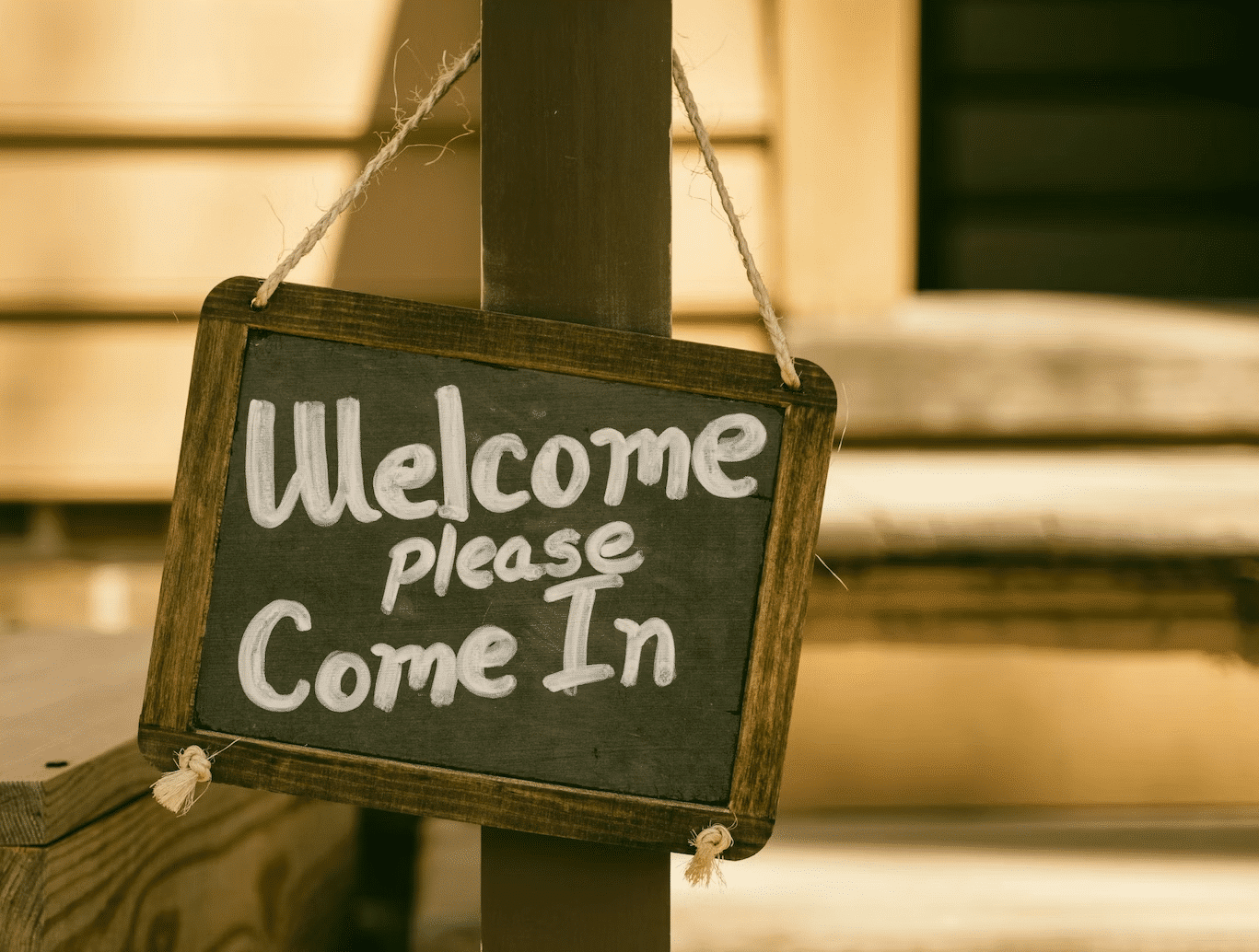 Chalk sign that says "Welcome please come in"